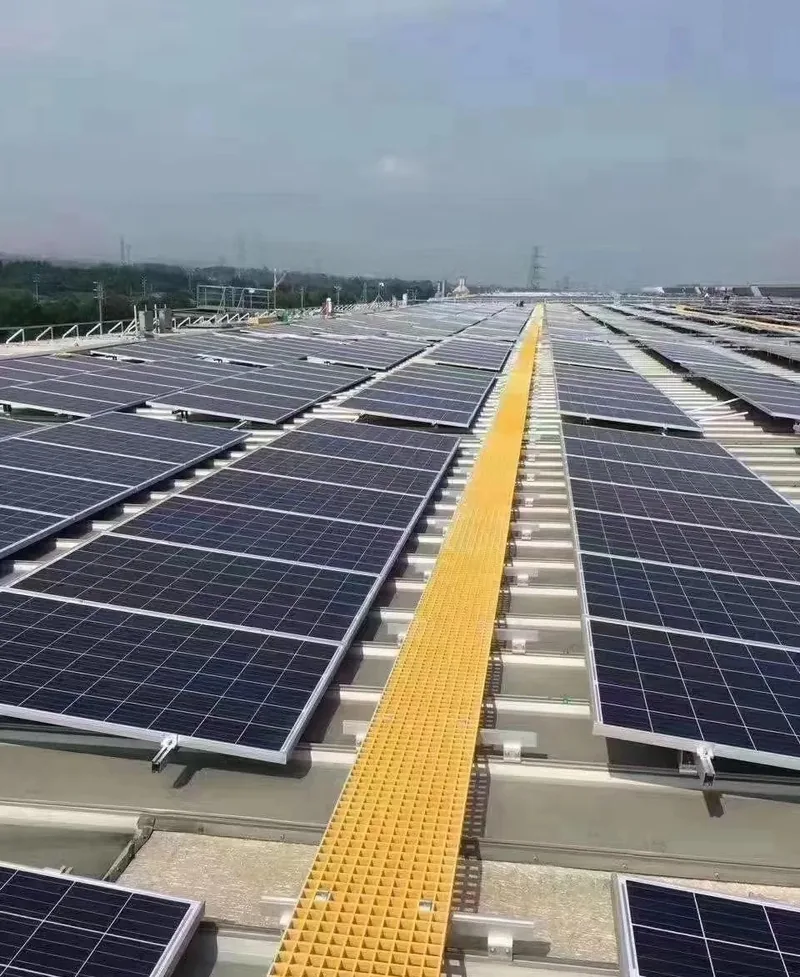 Yellow molded FRP grating walkway running between rows of solar panels