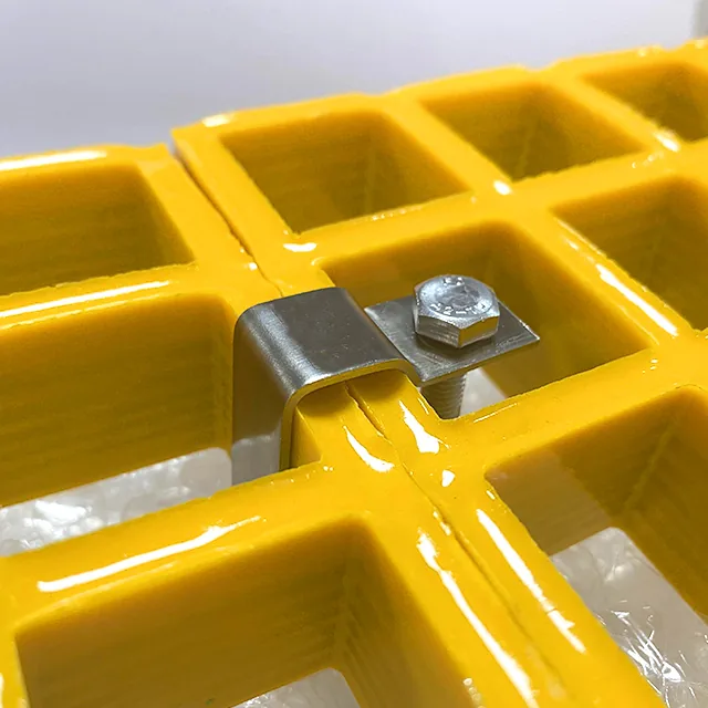Metal C clip connecting the edge bars of two yellow molded FRP grating panels with a bolted plate
