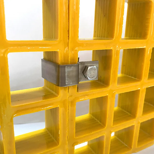 Two yellow molded FRP grating panels joined edge to edge with a metal connector and a bolted plate