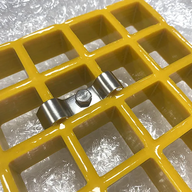 Stainless M clip fitted across two bars of a yellow molded FRP grating panel