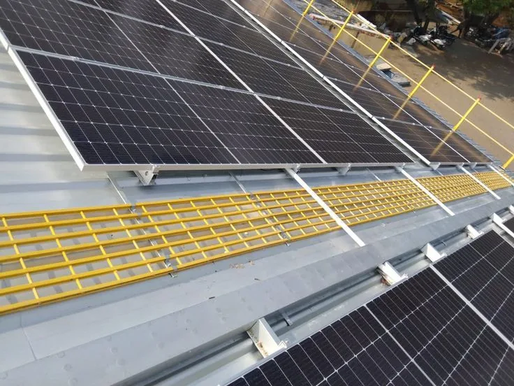 Yellow FRP grating walkway installed between rooftop solar panels