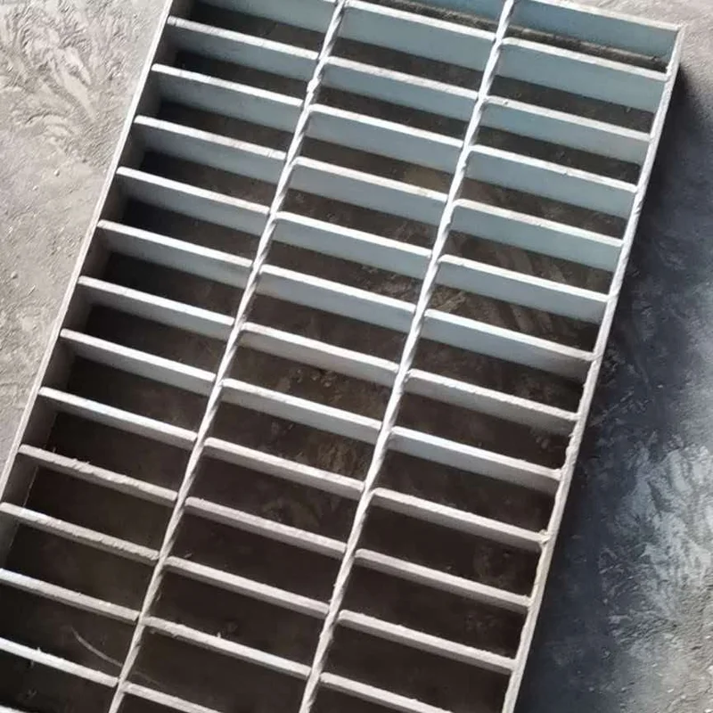 Steel bar grating panel showing parallel bearing bars and cross bars on a concrete surface